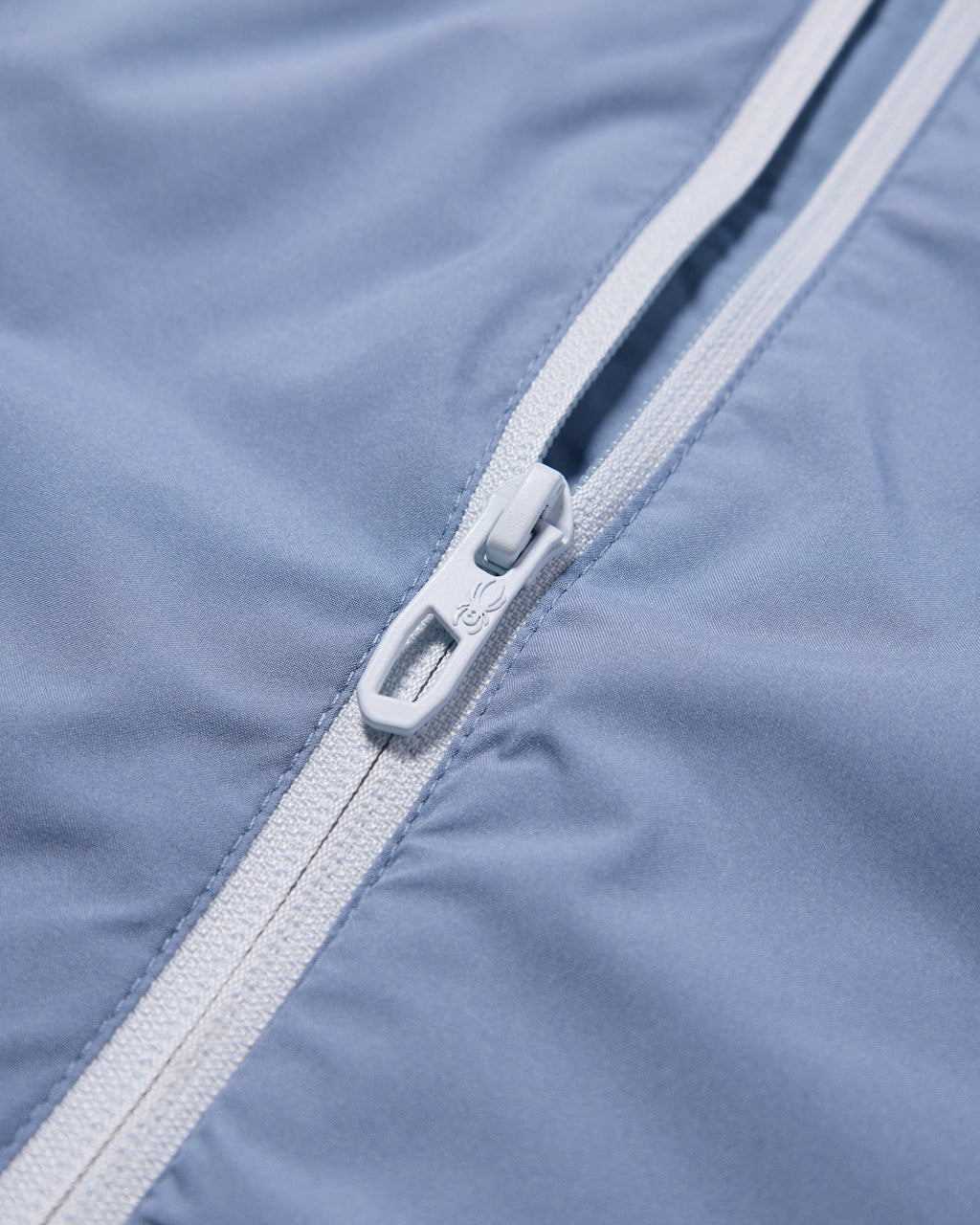 Close-up of a zipper on a blue fabric background