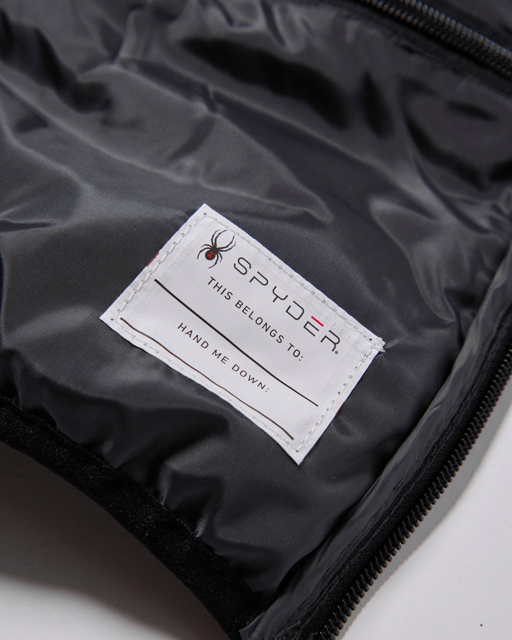 Spyder label on a black jacket with a spider logo