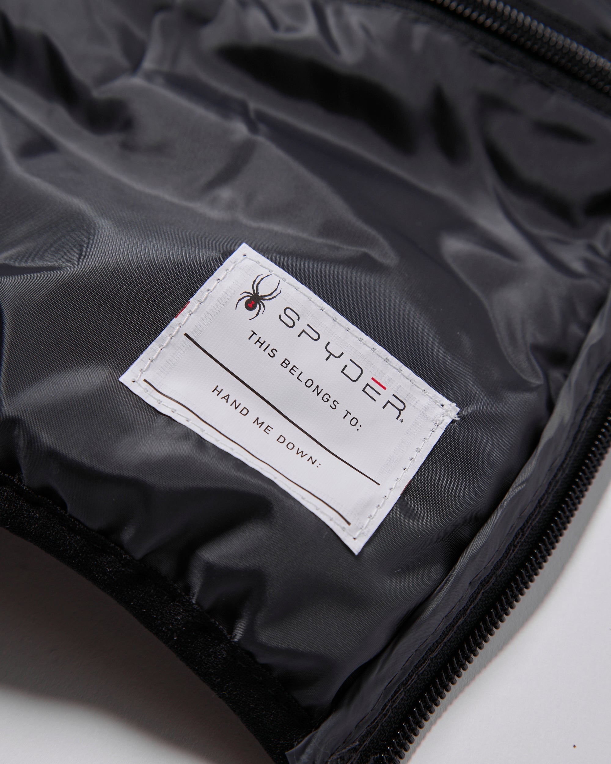 Spyder label on a black jacket with a spider logo