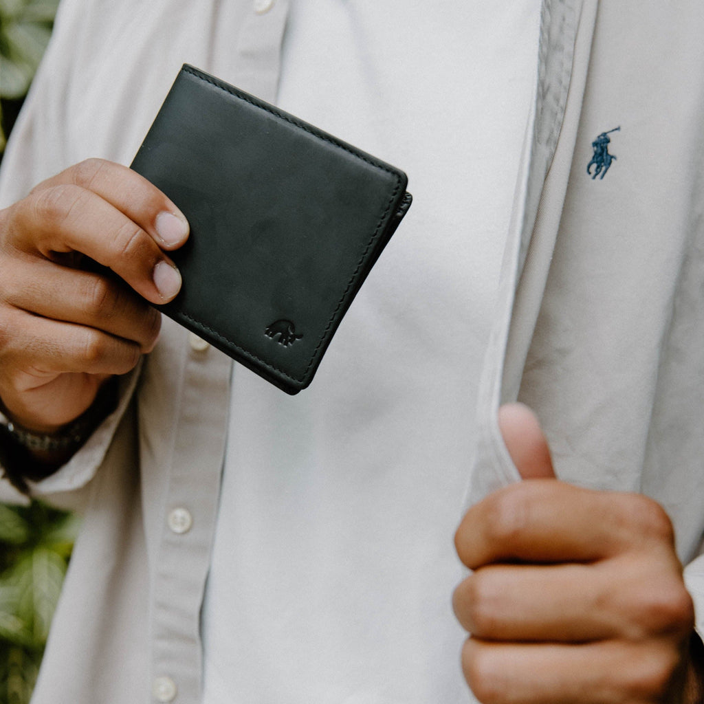 A person holding a Bifold Wallet - Black Edition, showcasing its design and texture.